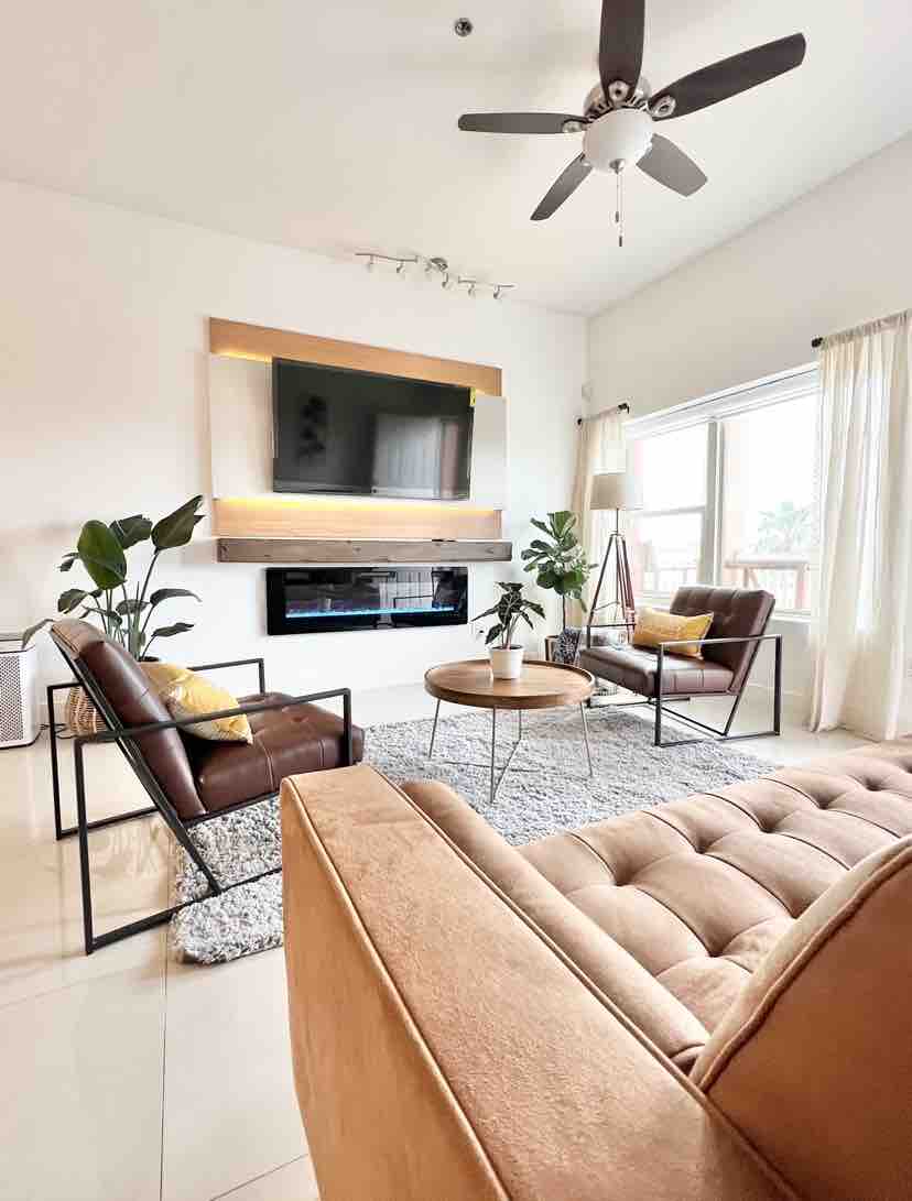 Bright, open living room with leather sofa and fireplace at The Sailor's Cabin